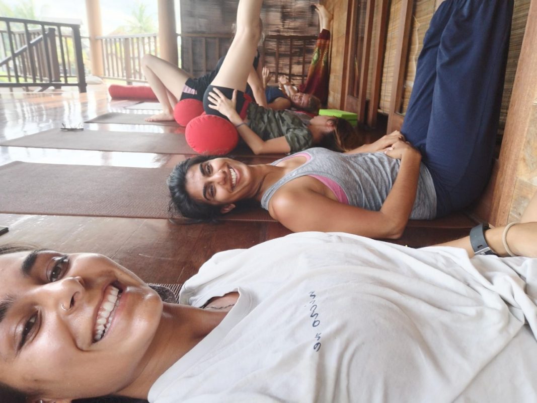 restorative yoga tijdens de yoga teacher training liggen we op de grond met bolsters en zijn we blij